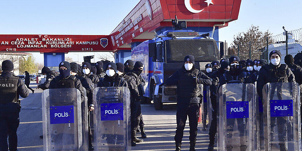 Polizeibeamte mit Mund-Nasen-Schutz und Schutzausrüstung stehen Wache am Eingang eines Luftwaffenstützpunktes, nahe eines Gerichtsgebäudes. Mehr als vier Jahre nach dem Putschversuch in der Türkei hat ein Gericht Urteile gegen Hunderte Beteiligte gefällt. Foto: Uncredited/AP/dpa