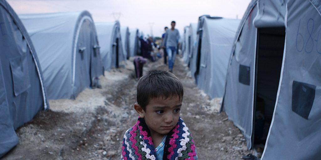 Ein syrischer Bub hüllt sich in einem Flüchtlingslager in der Türkei in eine Decke. (Archiv) Ein syrischer Bub hüllt sich in einem Flüchtlingslager in der Türkei in eine Decke. (Archiv)