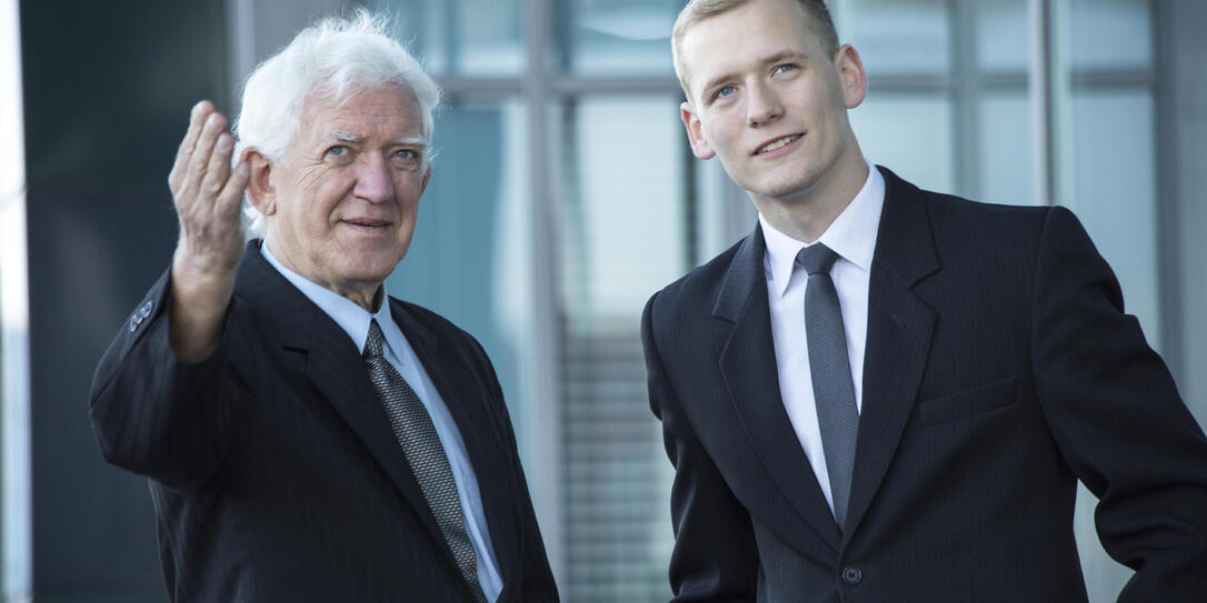 Young boss listening to senior worker