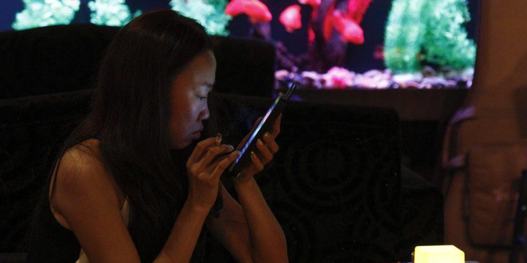 Eine Chinesin hält in einer Pekinger Bar eine Zigarette in der Hand und schaut auf ihr Smartphone. Gemäss der Studie in "The Lancet" waren unter den Raucher-Toten im Jahr 2010 neben 840'000 Männern auch 130'000 Frauen (Archiv)