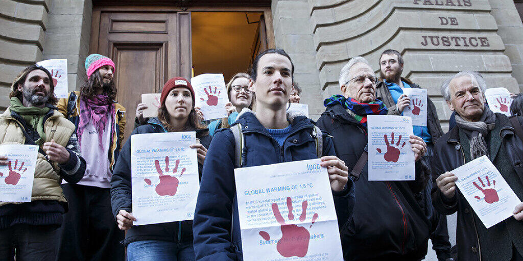 Der angeklagte Klimaaktivist (Mitte vorne) wird beim Gang ans Gericht von anderen Mitgliedern der Bewegung "Breakfree Schweiz" unterstützt. Auch der Stadtrat der Linken Alternative, Remy Pagani (rechts), bekundet seine Solidarität.