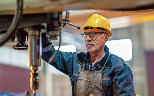 Turner worker working on drill bit in a workshop