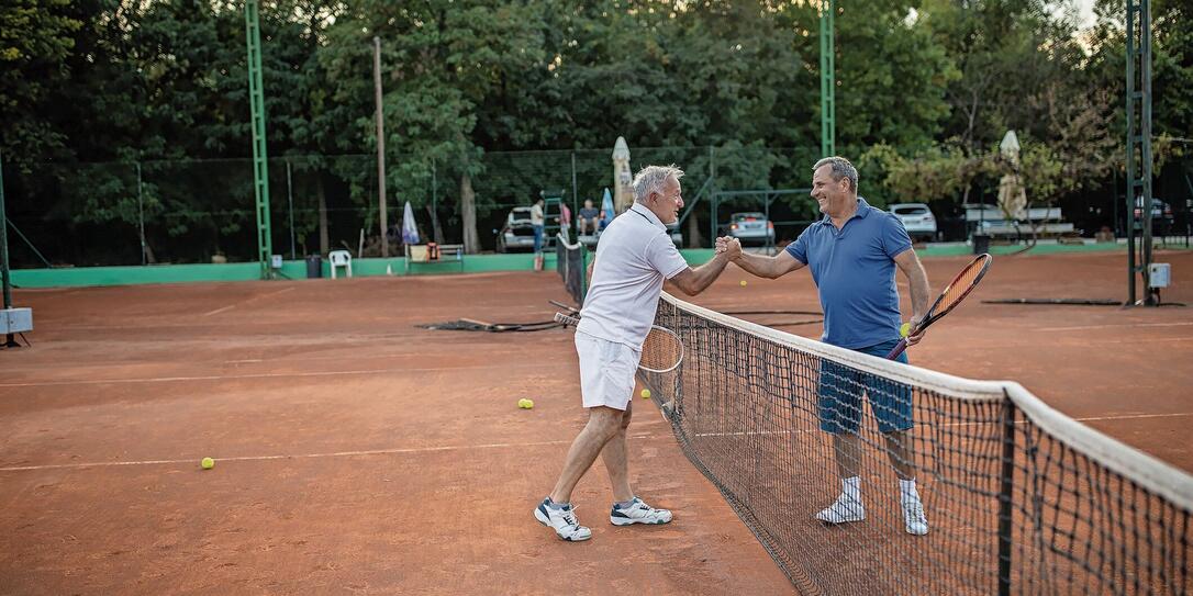 Two senior friends handshake before they start to play tennis Two senior friends handshake before they start to play tennis