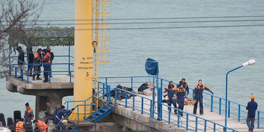 Rettungskräfte bringen Überreste an Land, die nach dem Absturz einer russischen Militärmaschine im Schwarzen Meer geborgen wurden.