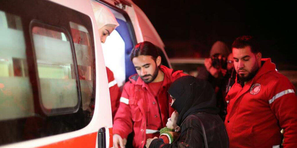 Helfer des syrischen Roten Halbmondes beim Transport Kranker in Ost-Ghuta