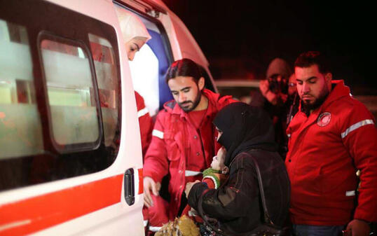 Helfer des syrischen Roten Halbmondes beim Transport Kranker in Ost-Ghuta