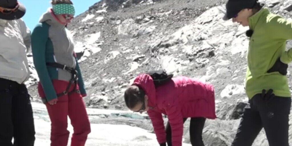 Mit dem Eisbohrer entnehmen die Schülerinnen einen Eisbohrkern aus dem Gletscher. An Eisbohrkernen und den eingeschlossenen Gasbläschen können Forschende die Klimavergangenheit rekonstruieren.