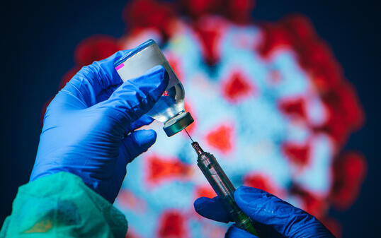 Coronavirus Covid-19 Protection and Vaccine. Doctor drawing up solution from vaccine bottle and filling syringe injection for patient vaccination in medical clinic, Coronavirus in background