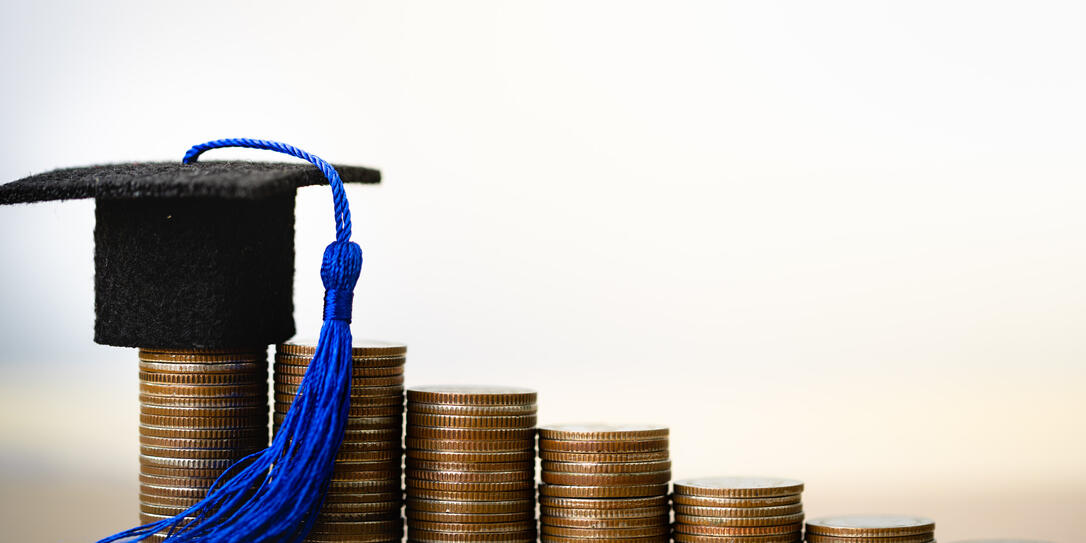 Graduation hat on coins money on white background.