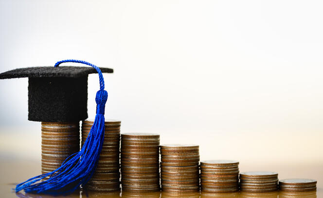Graduation hat on coins money on white background.
