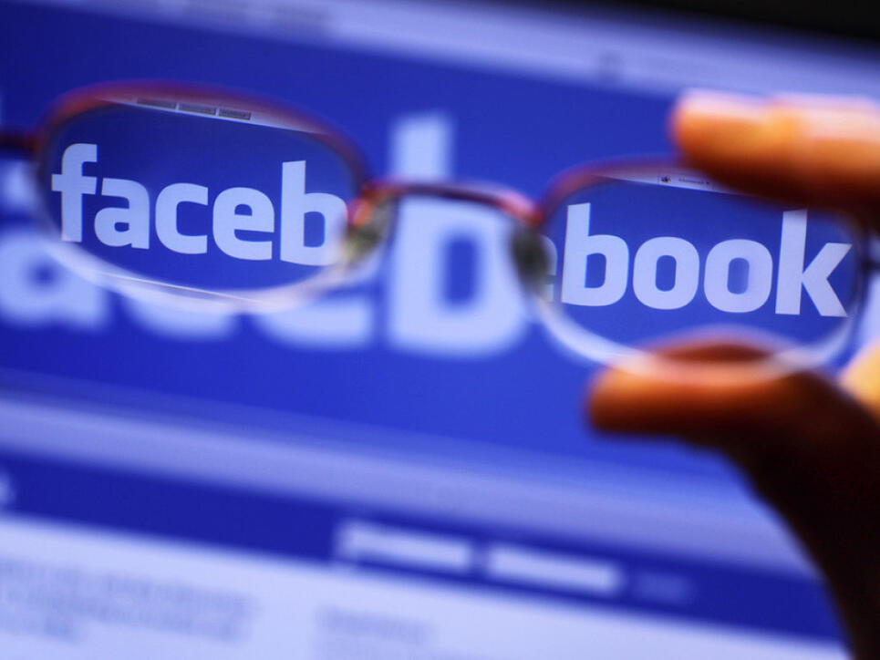 Durch die Gläser einer Brille ist der Schriftzug von Facebook auf einem Laptop zu sehen. (Symbolbild)