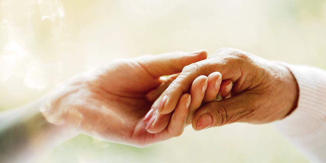 Young hand holding elderly hand