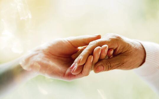 Young hand holding elderly hand