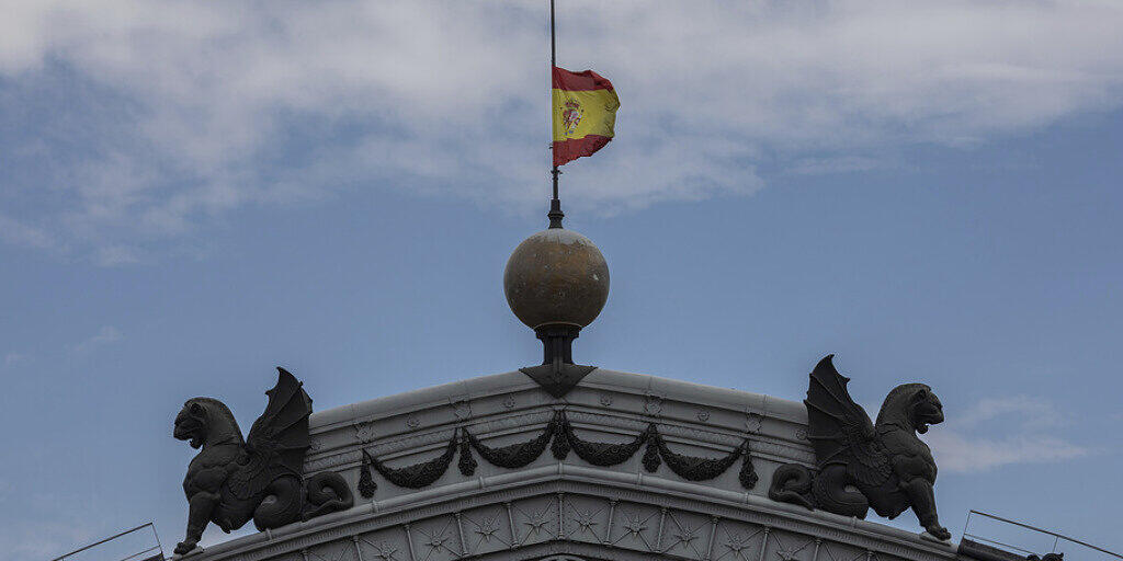 Spanische Fahne auf Halbmast am Dienstag auf dem Dach des Zugbahnhofs Atocha in Madrid. Spanien gedenkt der Corona-Opfer mit einer zehntägigen Staatstrauer.