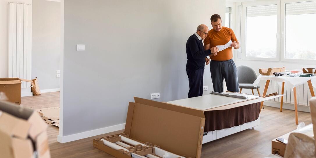 Handymen reading instruction manual for assembling the new furniture