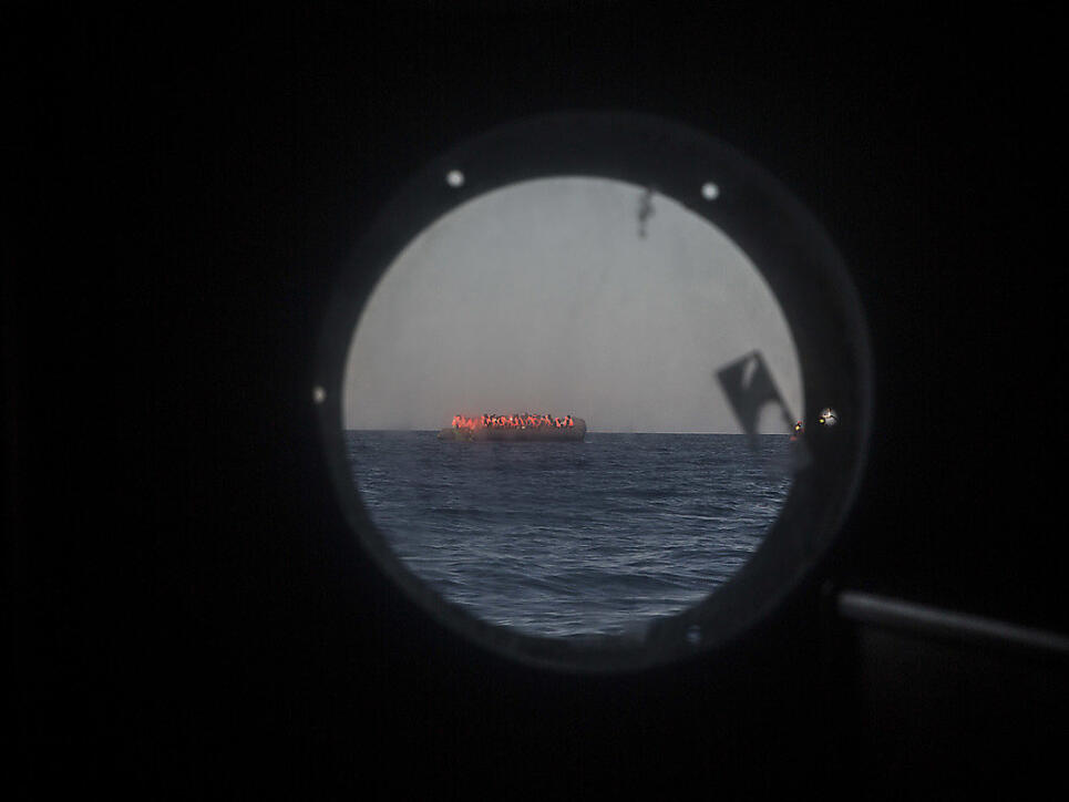 Überfülltes Flüchtlingsboot im Mittelmeer, gesehen durch ein Bullauge eines Schiffs der Hilfsorganisation "Proactiva Open Arms" (Archiv)
