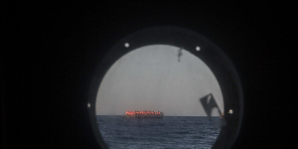 Überfülltes Flüchtlingsboot im Mittelmeer, gesehen durch ein Bullauge eines Schiffs der Hilfsorganisation "Proactiva Open Arms" (Archiv)