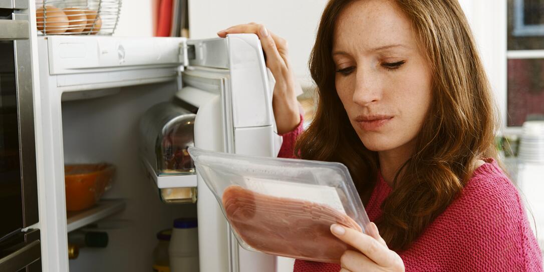 Concerned Woman Looking At Pre Packaged Meat