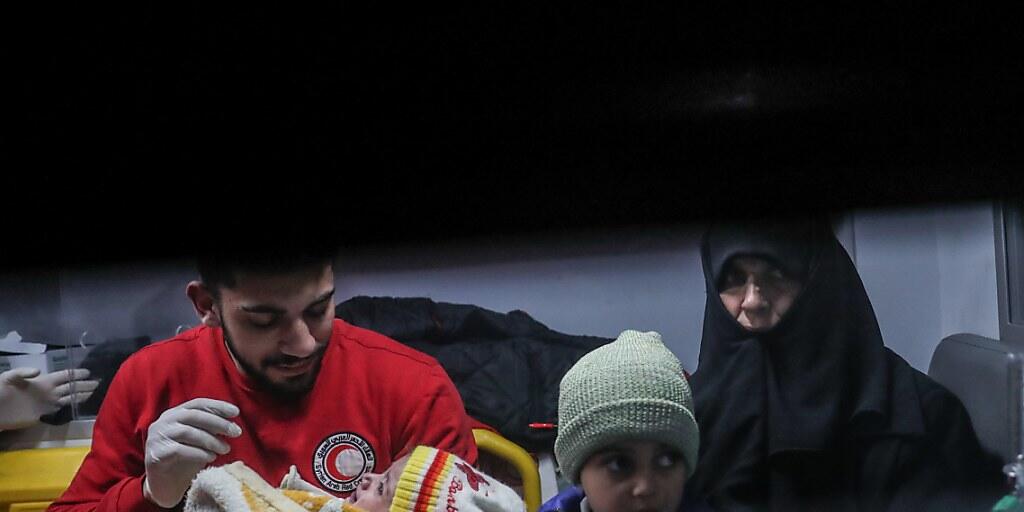 Rothalbmond-Helfer beim Abtransport eines kranken Kindes mit Angehörigen aus Ost-Ghuta