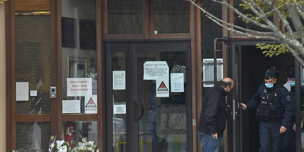 Blumen liegen vor der Mittelschule in Conflans-Saint-Honorine. Foto: Bertrand Guay/AFP/dpa