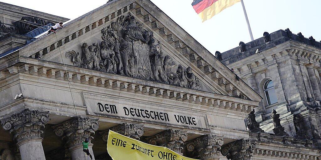 Greenpeace-Aktivisten seilen sich mit einem Transparent vom Reichstagsgebäude ab, auf dem geschrieben steht: «Eine Zukunft ohne Kohlekraft». Der Bundestag verabschiedet heute ein neues Kohlegesetz. Foto: Kay Nietfeld/dpa