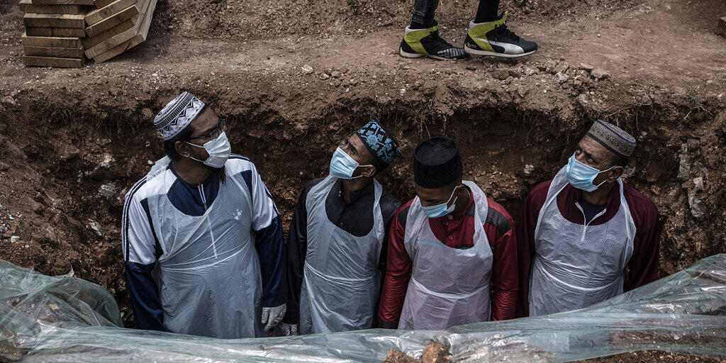 dpatopbilder - Bestatter in Schutzkleidung bereiten das Grab für eine an dem Coronavirus verstorbenen Person auf dem Avalon-Friedhof in Johannesburg für die Beerdigung vor. Foto: Shiraaz Mohamed/AP/dpa dpatopbilder - Bestatter in Schutzkleidung bereiten das Grab für eine an dem Coronavirus verstorbenen Person auf dem Avalon-Friedhof in Johannesburg für die Beerdigung vor. Foto: Shiraaz Mohamed/AP/dpa
