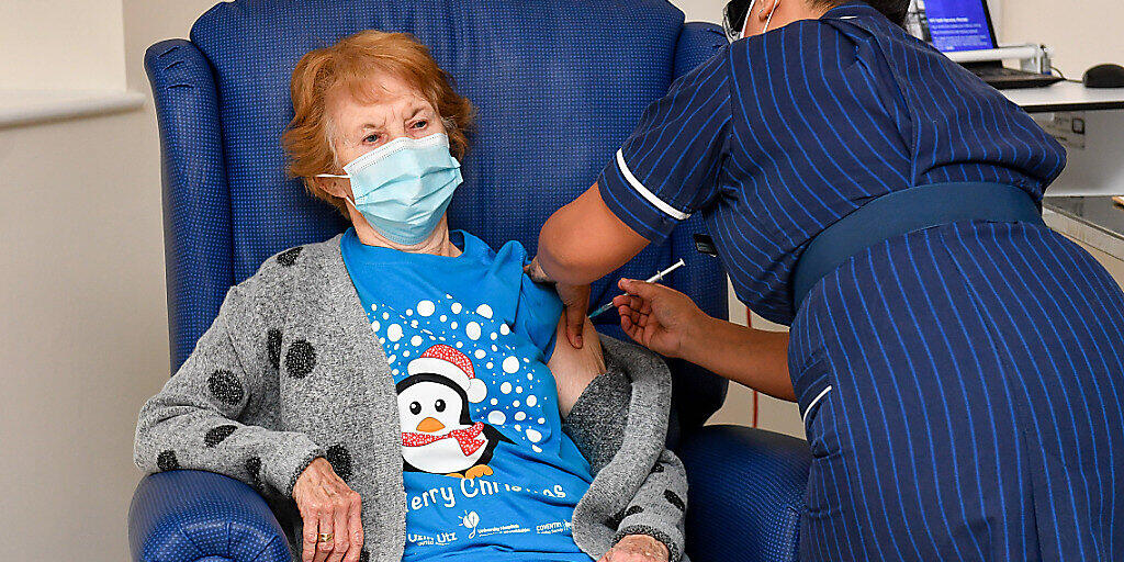 Die 90-jährige Margaret Keenan (l) bekommt im Universitätskrankenhaus Coventry von der Krankenschwester May Parsons den Pfizer/BioNtech-Impfstoff gegen das neuartige Coronavirus. Foto: Jacob King/PA Wire/dpa Die 90-jährige Margaret Keenan (l) bekommt im Universitätskrankenhaus Coventry von der Krankenschwester May Parsons den Pfizer/BioNtech-Impfstoff gegen das neuartige Coronavirus. Foto: Jacob King/PA Wire/dpa