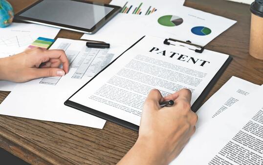 Business woman signs a patent. Intellectual property protection concept. Patent attorney.