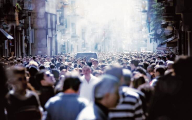 Crowd of people walking on busy city street