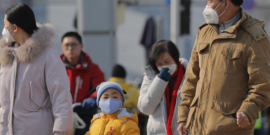 Diese Menschen in Peking schützen sich mit Gesichtsmasken vor der neuen Lungenkrankheit. Diese Menschen in Peking schützen sich mit Gesichtsmasken vor der neuen Lungenkrankheit.
