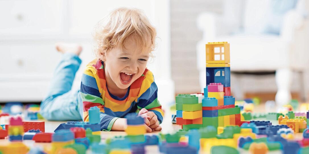 Child playing with toy blocks. Toys for kids.