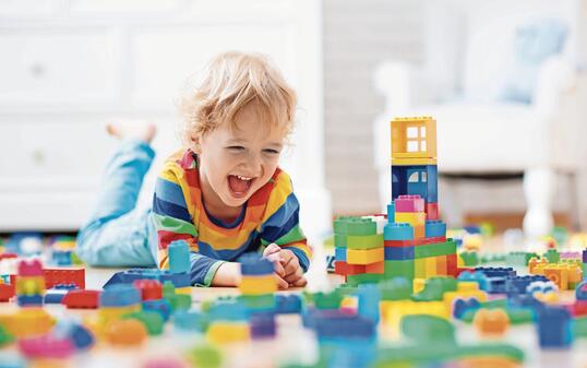 Child playing with toy blocks. Toys for kids.