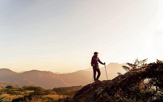 A man hiking with a view from the rock
