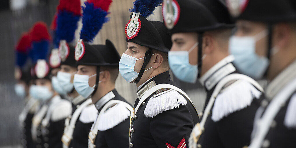 Eine Gruppe italienischer Carabinieri trägt während der Feierlichkeiten zum Tag der Streitkräfte Mund-Nasen-Schutz. Foto: Alessandra Tarantino/AP/dpa Eine Gruppe italienischer Carabinieri trägt während der Feierlichkeiten zum Tag der Streitkräfte Mund-Nasen-Schutz. Foto: Alessandra Tarantino/AP/dpa