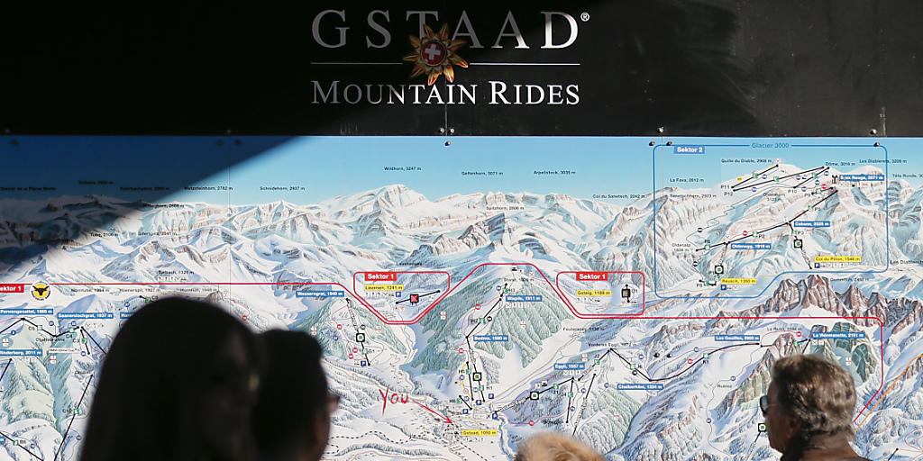 Touristen konsultieren eine Übersichtskarte der Gstaader Bergbahnen. Nach finanziellen Schwierigkeiten sind die Bahnen in den letzten Monaten saniert worden. Eine wichtige Rolle spielten dabei finanzkräftige private Investoren.
