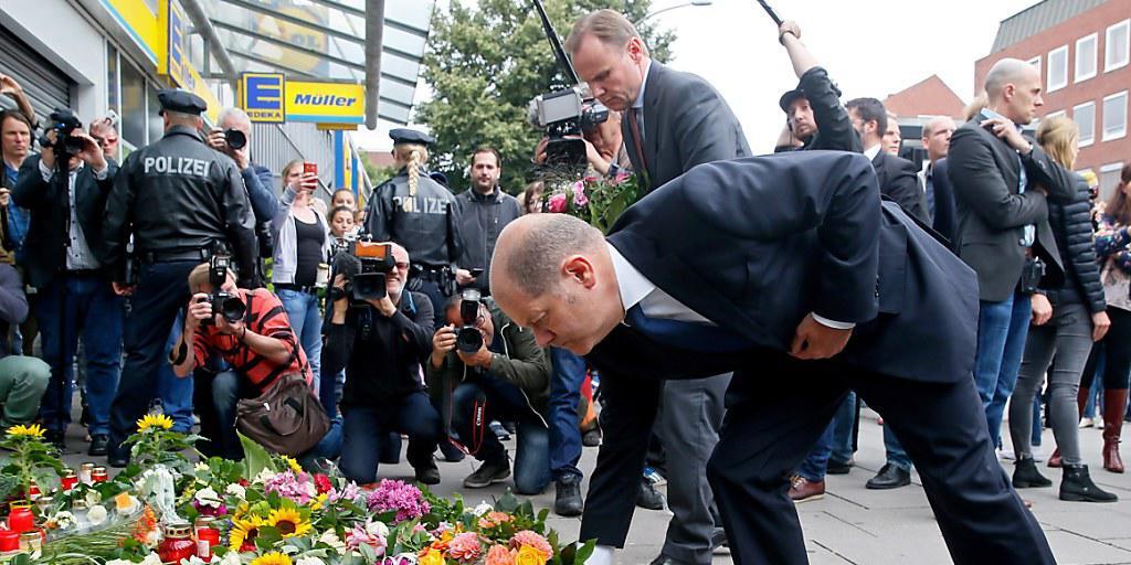 Der Hamburger Bürgermeister Olaf Scholz legt Blumen nieder am Tatort des palästinensischen Messer-Angreifers im Stadtteil Barmbek.