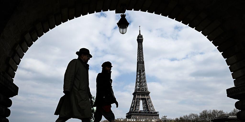 ARCHIV - Passanten gehen auf der Brücke «Pont de Bir-Hakeim», mit Blick auf den Eiffelturm. Foto: Philippe Lopez/AFP/dpa ARCHIV - Passanten gehen auf der Brücke «Pont de Bir-Hakeim», mit Blick auf den Eiffelturm. Foto: Philippe Lopez/AFP/dpa