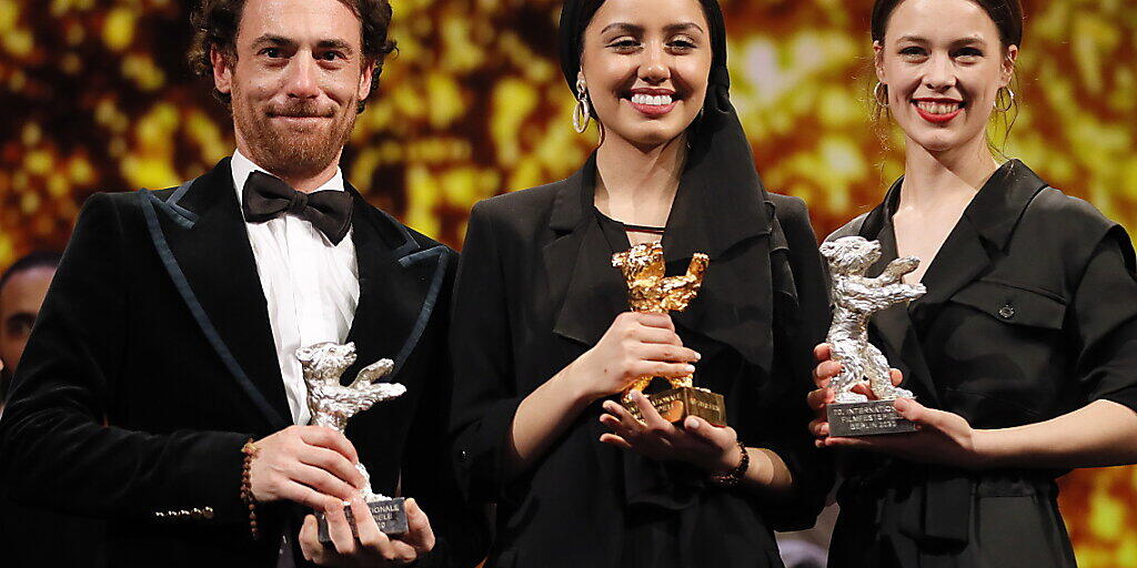 Die Tochter des iranischen Preisträger-Regisseurs, Baran Rassulof (Mitte), nimmt in Berlin den Goldenen Bären für ihren Vater in Empfang, der nicht ausreisen durfte. Umrahmt wird sie von der besten Darstellerin Paula Beer (rechts) und dem besten Darsteller Elio Germano.