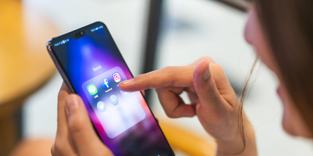 Asian woman using social media application on Huawei P20 pro smartphone, pointing at facebook app. Illustrative Editorial content.