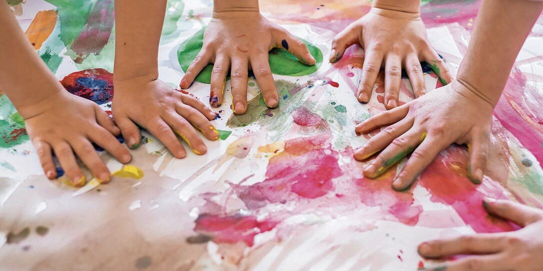 Close up colored kids hands on the table Close up colored kids hands on the table