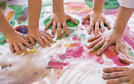 Close up colored kids hands on the table
