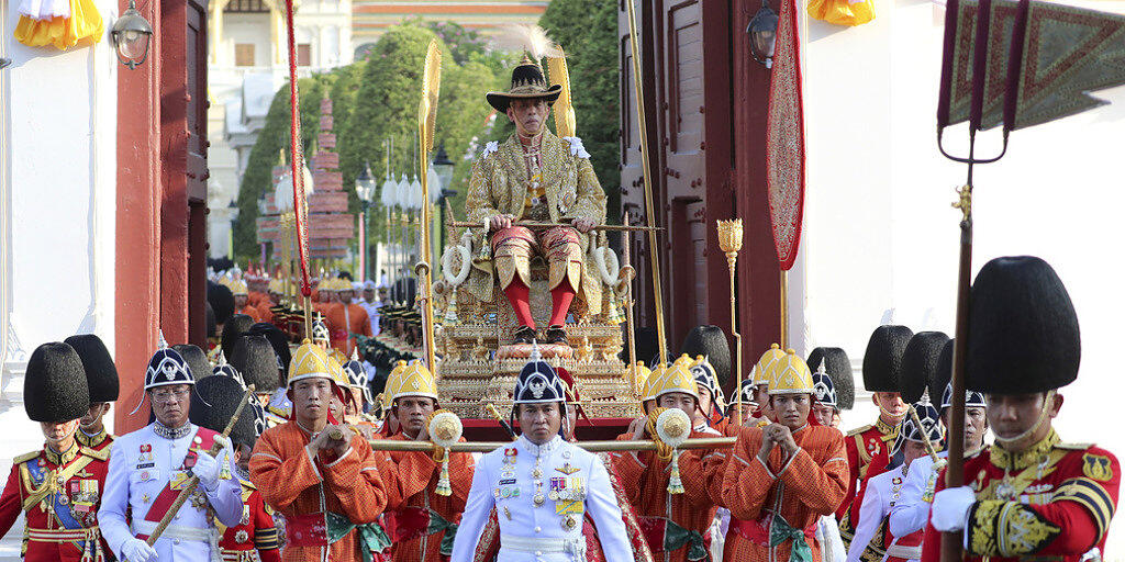 Der neu gekrönte thailändische König Maha Vajiralongkorn wird von seiner königlichen Garde auf einer Sänfte durch die Strassen der Hauptstadt Bangkok getragen.
