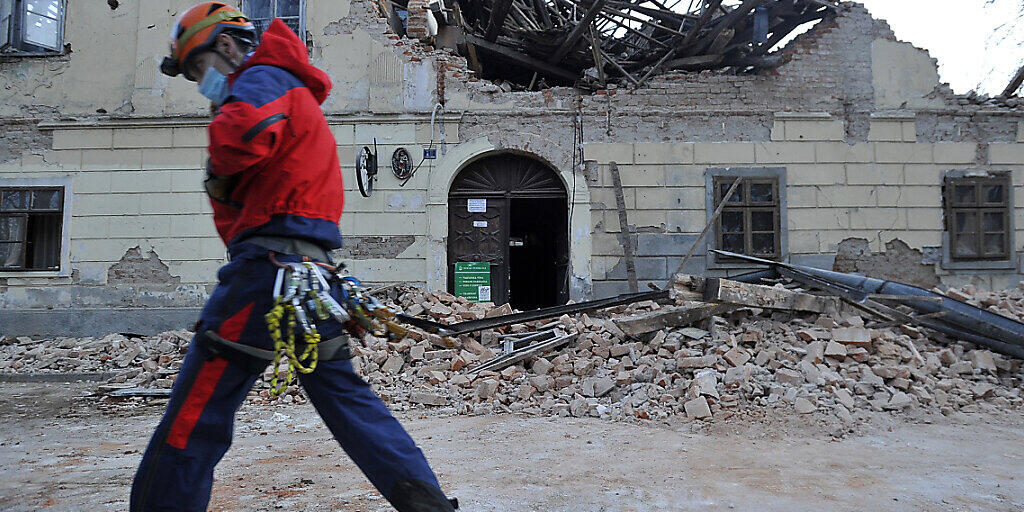 dpatopbilder - Ein Mitglied der Rettungskräfte geht vor den Trümmern eines durch ein Erdbeben eingestürzten Hauses vorbei. Foto: Uncredited/AP/dpa