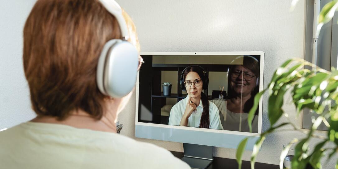 Senior adult plus size woman having online psychotherapy session with professional psychologist using computer at home. Digital service business