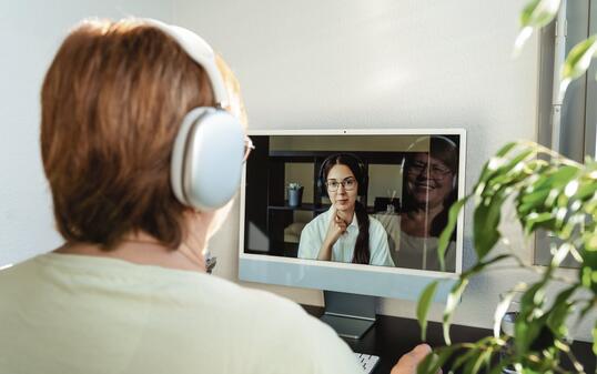 Senior adult plus size woman having online psychotherapy session with professional psychologist using computer at home. Digital service business