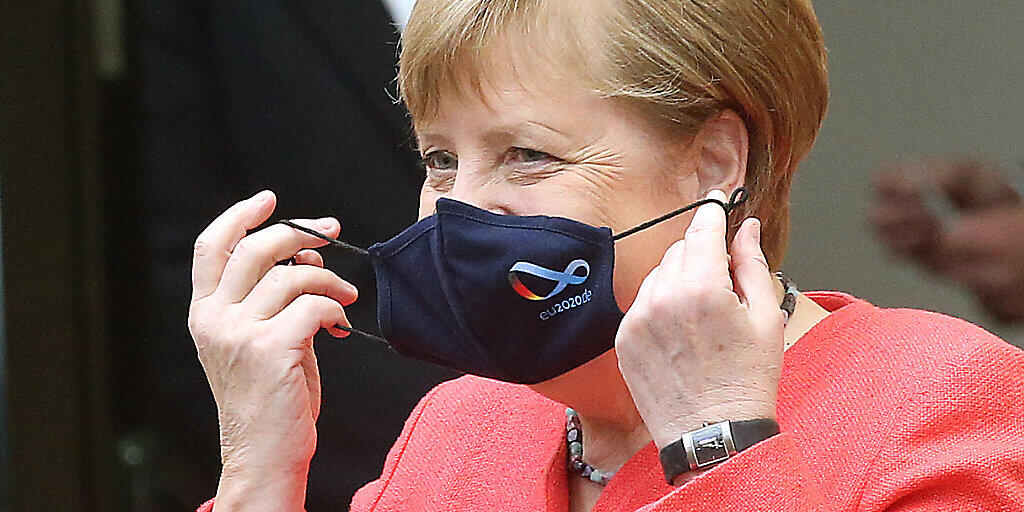 dpatopbilder - Bundeskanzlerin Angela Merkel (CDU) nimmt im Bundesrat ihre Mund- und Nasenschutzmaske ab, bevor sie eine Rede zu Zielen der EU-Ratspräsidentschaft hält. Foto: Wolfgang Kumm/dpa dpatopbilder - Bundeskanzlerin Angela Merkel (CDU) nimmt im Bundesrat ihre Mund- und Nasenschutzmaske ab, bevor sie eine Rede zu Zielen der EU-Ratspräsidentschaft hält. Foto: Wolfgang Kumm/dpa