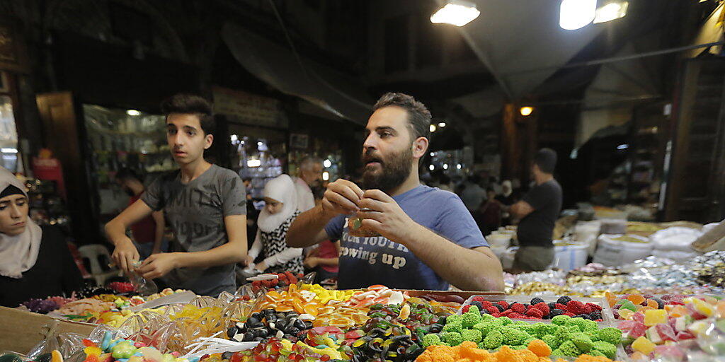 Die Menschen in Syrien decken sich auf einem Markt in Damaskus mit Süssigkeiten ein für Eid al-Fitr, das Fastenbrechen nach dem Ramadan.