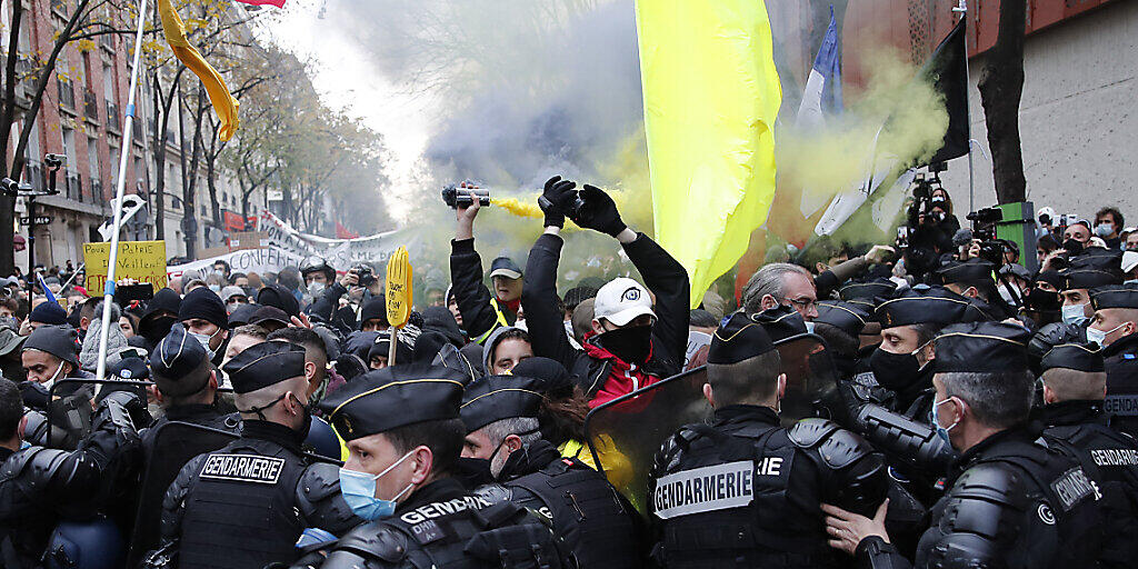 Polizisten blockieren Demonstranten bei einem Protest gegen Polizeigewalt und Rassismus. Der Protest bezieht sich auf Aufnahmen eines Vorfalls im vergangenen Monat, bei dem Polizisten einen Schwarzen geschlagen haben sollen. Foto: Francois Mori/AP/dpa