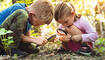 Kids exploring in forest with a magnifying glass