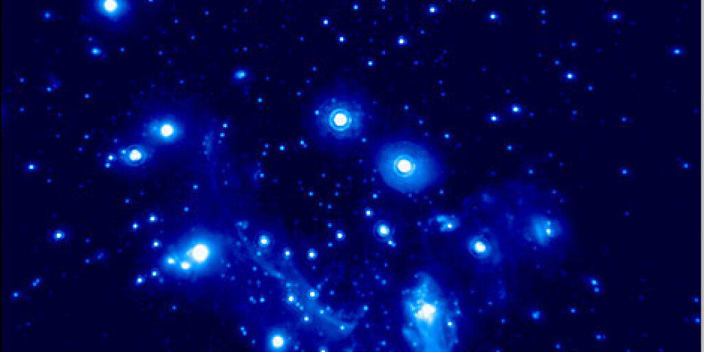 Das Schwarze Loch im Zentrum unserer Galaxie und die Gruppe von Himmelskörpern, die es umkreisen. Astronomen haben daran die Gravitationsrotverschiebung nachgewiesen. Sie ist eine weitere Bestätigung für Einsteins Relativitätstheorie.